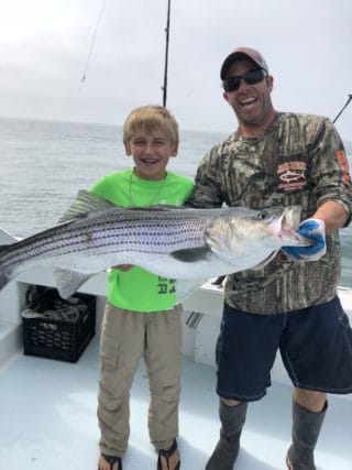 Captain Seamus Muldoon and a young boy holding a fish